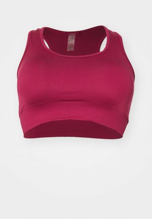 Sportovní podprsenka v tmavě růžové barvě, vyrobená z elastického materiálu s hladkou texturou, s designem na zádech typu racerback a širokým lemem.