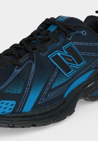 Μπλε και μαύρο αθλητικό παπούτσι New Balance με μαύρα κορδόνια, μαλακή σόλα και λογότυπο N Lock στο πλάι.