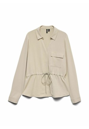 Blouse beige à manches longues avec col, poche poitrine unique avec rabat, et taille à cordon ajustable, présentée à plat sur fond blanc.