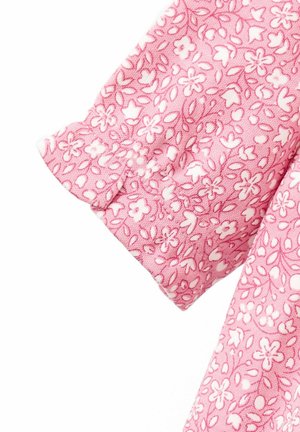 Material roz cu un model floral, având flori și frunze albe. Mâneca are un detaliu cu manșetă strânsă. Textură moale.