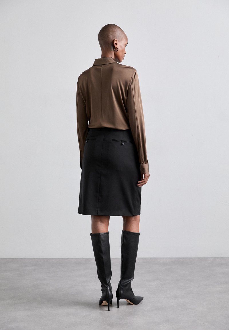 Brown long-sleeve shirt with a collar, black knee-length skirt, and black high-heeled boots, featuring a smooth texture and tailored fit.