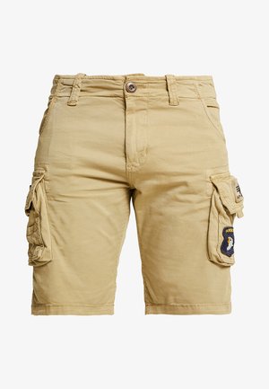 Beige cargo shorts yang terbuat dari katun, dilengkapi dengan dua saku samping dan sebuah tambalan dengan lambang di saku kanan. Penutupan dengan kancing dan ritsleting.