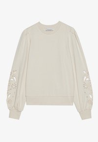 Kremowa bluza wykonana z miękkiego materiału, z bufkami i wyciętymi wzorami kwiatowymi oraz ściągaczem u dołu.