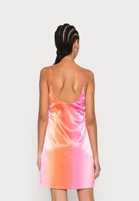 Vestido de seda con un degradado de rosa a naranja, tirantes ajustables, espalda baja y textura suave.