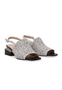 Sølv åbne slingback sko med et tekstureret mønster og en lav blokhæl. Har en justerbar ankelrem og sorte sål accenter.