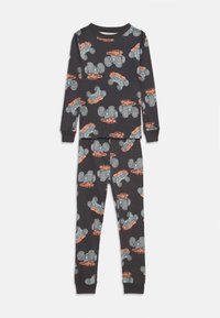 Ensemble de pyjama noir comprenant un haut à manches longues et un pantalon, orné d'un motif de camions monstres orange et bleu sur un fond noir.