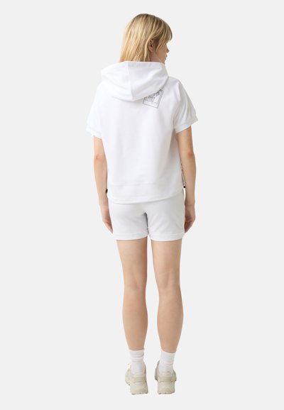 White hooded sweatshirt with short sleeves and a graphic detail on the back, paired with white shorts and light-colored sneakers.