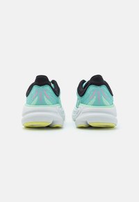 Chaussures de course légères avec une tige en maille vert menthe, des accents noirs et une semelle épaisse blanche avec des détails jaunes. Marque Bondi 9 sur le talon.