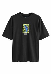 Black cotton t-shirt with a colorful graphic featuring a blue shark on a yellow background. Loose fit with short sleeves.