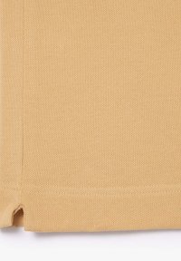 Tan tyg med en texturerad, nätliknande mönster. Har en ren kant med en liten reva i botten. Lämplig för olika tillämpningar.