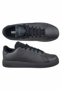 Čierne športové topánky s hladkým syntetickým zvrškom, ktoré majú perforovaný dizajn s tromi pruhmi, okrúhlu špičku a plochú gumovú podrážku.