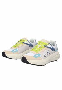 Sneakers realizzati con un mix di materiali; tomaia grigia chiara, accenti blu e beige, lacci verde brillante, suola intermedia spessa bianca e suola nera.