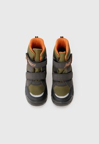 Zapatillas altas verdes y negras con acentos naranjas, que presentan una tela de malla, dos correas de velcro y una suela de goma.
