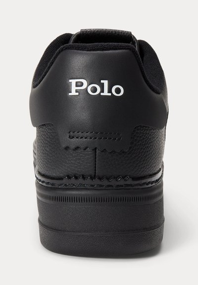 Juodas odinis sportbačiai matomi iš nugaros su balta „Polo“ ženklinimu ant kulno apykaklės ir tekstūruota padu.