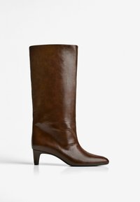 Bottine en cuir marron avec un bout pointu, tige ajustée et un talon conique. Texture lisse avec une finition brillante.