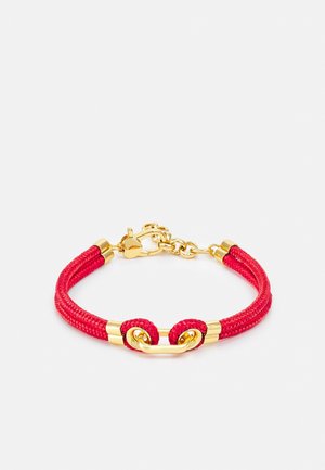Bracelet ajustable avec cordon tressé rouge, accents métalliques dorés et fermeture à clip dorée.