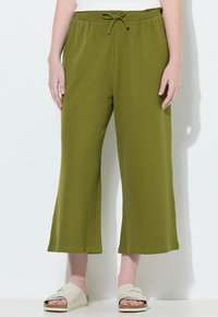 Groene, wijde broek van textuurstof met een trekkoord in de taille. Gemaakt met neutrale instap sandaaltjes.