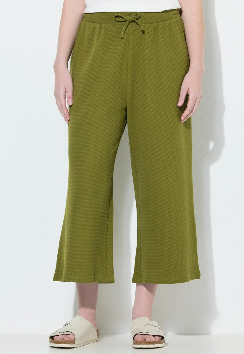 Groene, wijde broek van textuurstof met een trekkoord in de taille. Gemaakt met neutrale instap sandaaltjes.