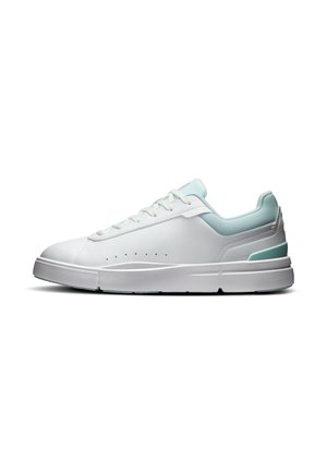 Hvid sneakers med lav snude med lyseblå polstret krave, hvide snørebånd og tyk hvid sål, vist fra siden på hvid baggrund.