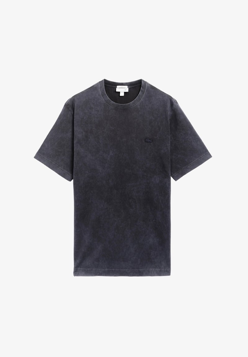 Camiseta de algodón gris oscuro con cuello redondo, mangas cortas y una sutil textura envejecida. Presenta un pequeño logo bordado en el pecho.