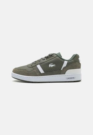 Zapatillas verdes de ante y materiales sintéticos, con acentos blancos, una suela texturizada y un logotipo en el costado.