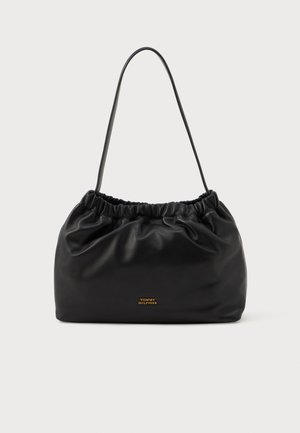 Sac à main en cuir noir avec un haut froncé et une bandoulière simple. Présente un accent logo doré à l'avant. Texture douce et lisse.
