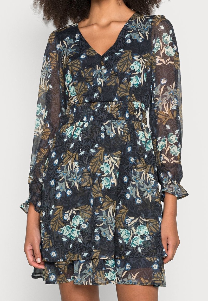 Robe florale avec un décolleté en V profond, des manches longues en voile, une taille froncée et une jupe à volants dans des motifs floraux bleu foncé, vert et beige.
