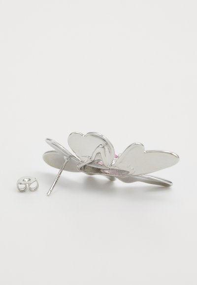 Spilla a forma di farfalla in argento con ali a forma di cuore, caratterizzata da dettagli rosa e un fermo a spillo. Include una chiusura posteriore staccabile. Texture liscia.