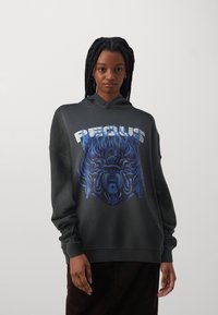 Sudadera negra con un diseño gráfico frontal que presenta llamas azules y una cara. Cuenta con un bolsillo canguro y una capucha clásica.