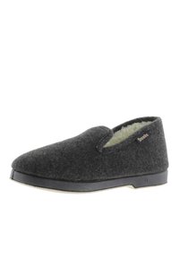 Zapatilla de lana gris con interior suave, diseño de fácil colocación, punta redondeada y suela de goma negra. Presenta una etiqueta de marca en el costado.