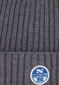 Beanie grigia lavorata a maglia con righe verticali. Presenta un patch rotondo blu e bianco con il logo di "North Sails" ben in evidenza sul davanti.