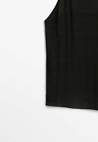 Haut court noir sans manches à côtes, présenté sur fond blanc, mettant en valeur la texture du tissu et l'ourlet droit.