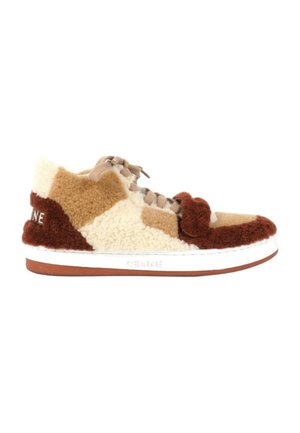 Baskets basses avec design patchwork en shearling et suède marron, beige et crème, lacets beiges, semelle blanche et nom de la marque sur le côté et le talon.