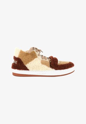 Zapatilla baja con diseño patchwork en piel de oveja y ante en marrón, beige y crema, cordones beige, suela blanca y nombre de la marca en el lateral y talón.