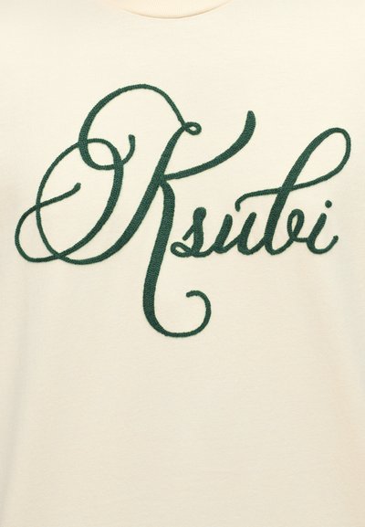 Κρεμ t-shirt με κεντημένο πράσινο λογότυπο σε καλλιγραφική γραφή "Ksubi" στο στήθος. Απαλή υφή, κλασικός στρογγυλός λαιμός.