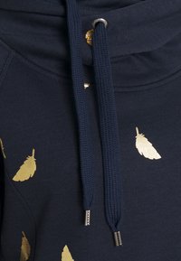 Felpa blu navy in tessuto con stampa di piume metalliche dorate e spesse stringhe blu navy con punte in metallo e occhielli.