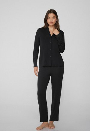 Conjunto de pijama negro con parte superior de botones de manga larga y pantalones a juego. Tela suave, corte recto, diseño minimalista sin estampados ni detalles.
