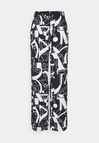 Svartvita vida byxor med ett grafiskt mönster av abstrakta former och bokstäver. Tillverkade av ett mjukt material med resår i midjan.