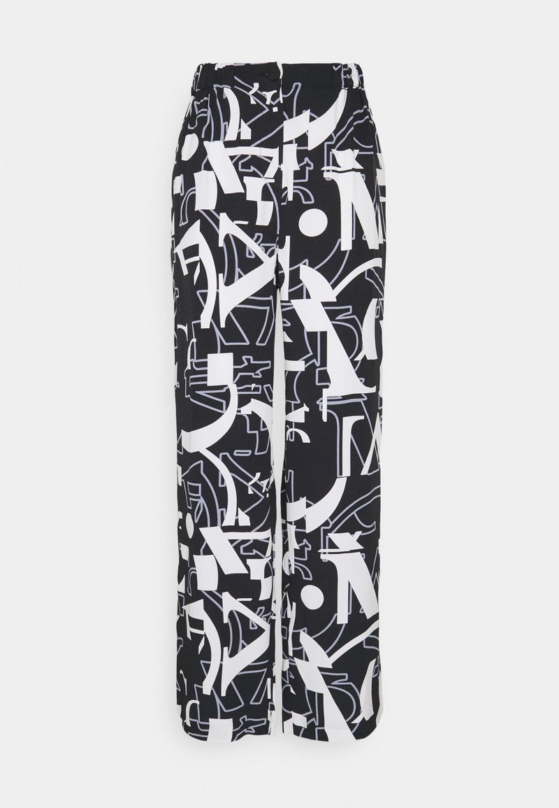 Svartvita vida byxor med ett grafiskt mönster av abstrakta former och bokstäver. Tillverkade av ett mjukt material med resår i midjan.