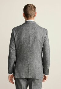 Gray houndstooth-patterned suit jacket with a tailored fit, notch lapels, and buttoned sleeves, displayed from the back.