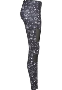 Svarta leggings med vita himmelska mönster, inklusive stjärnor och planeter. Nätpaneler ger andningsförmåga. Tillverkade av stretchigt material.