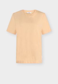 Krótki rękaw, brzoskwiniowy t-shirt. Wykonany z miękkiej tkaniny z okrągłym dekoltem. Subtelne logo nadrukowane na piersi. Prosty dół i luźny krój.