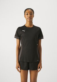 Black athletic t-shirt with short sleeves and a round neckline. Features white logo on the chest and gray accents on the sides. Smooth texture.