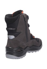 Grijze wandelschoen van suede en mesh, met ritsen, zwarte accenten, een getextureerde rubberen zool en oranje details bij de kraag.