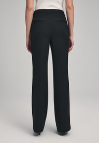 Pantaloni neri a vita alta, larghi, con una texture liscia e tasche posteriori sottili, caratterizzati da una vestibilità pulita e sartoriale.