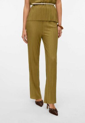 Olijfgroene geplooide broek met een rechte snit, gecombineerd met donkere hakken. Gladde textuur en subtiele glans, met een strakke tailleband.