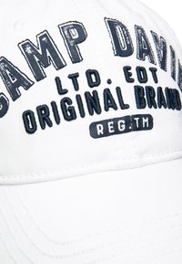 Weiße Baseballmütze mit gesticktem Text: "CAMP DAVID LTD. EDT ORIGINAL BRAND." Kontrastierende marinefarbene Nähte betonen das Design.