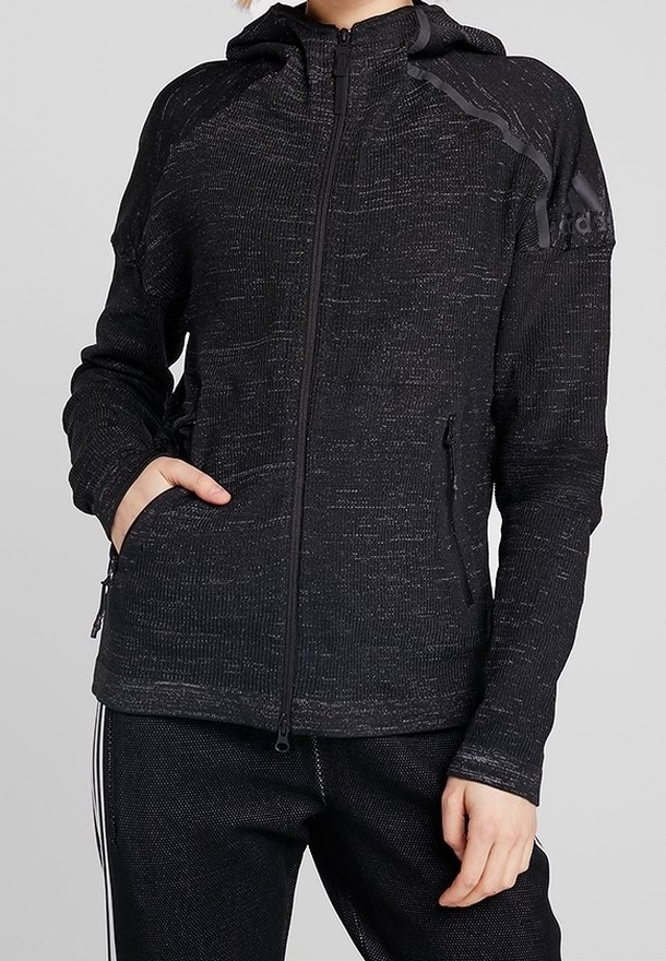 Czarna bluza rozpinana z teksturowanym splotem, kapturem i bocznymi kieszeniami. Posiada subtelne paski i logo Adidasa na górnej lewej stronie.