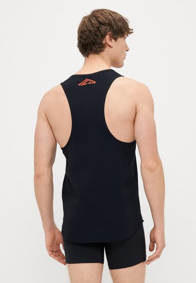 Črna brezrokavnik s krožnim ovratnikom, na hrbtni strani z rdečim logotipom "ICON". Tkanina izgleda gladka in prilegajoča.