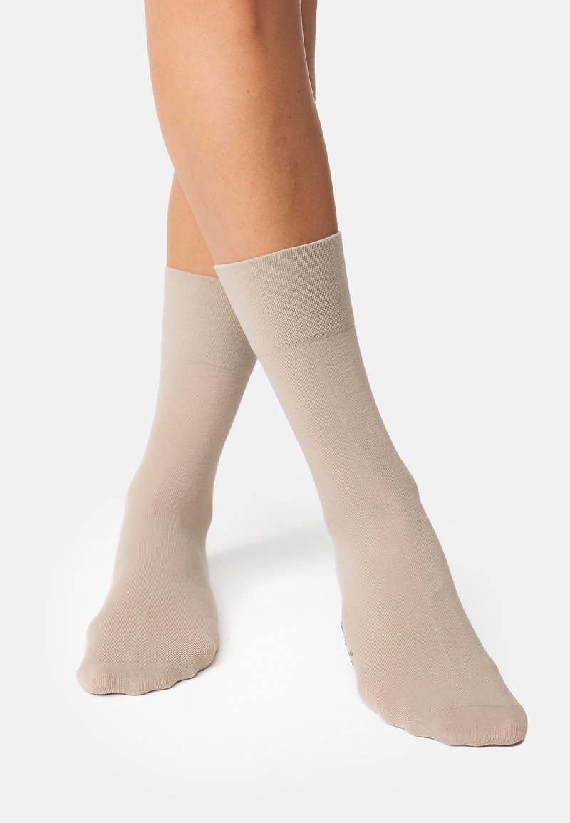 Calze alla caviglia beige realizzate in un materiale morbido e elastico, con un bordo a coste e una punta senza cuciture per il massimo comfort.